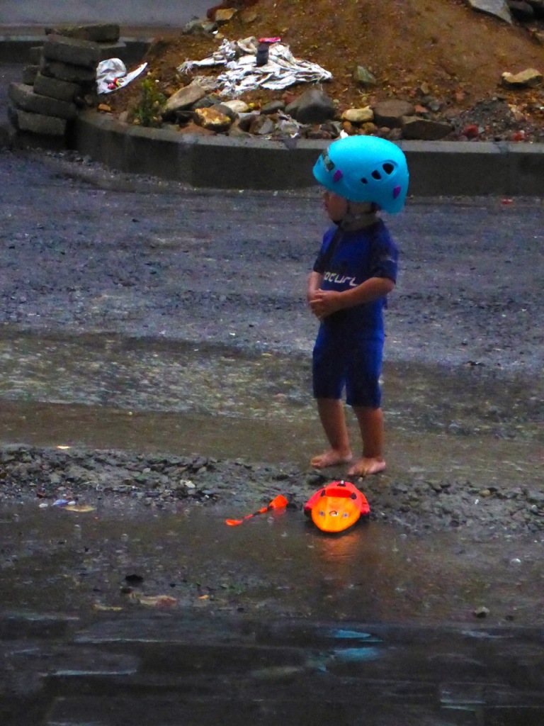 Our river guide - just kidding! This was the owner's son playing in front of the shop. So cute with this rafting helmet and mini-kayak